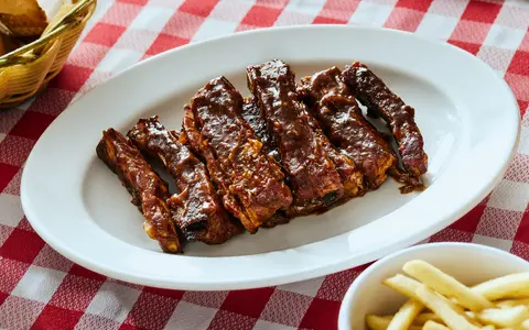 Costillas servidas con papas en Restaurante Bronco