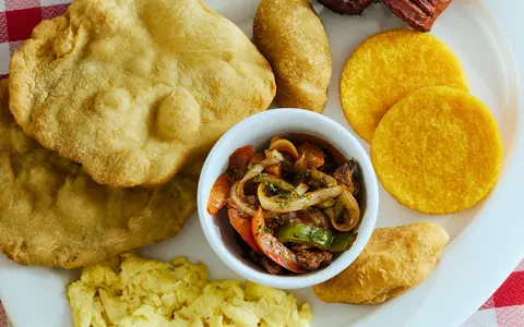 Desayuno panameño con hojaldres, tortillas, huevos y bistec en Bronco